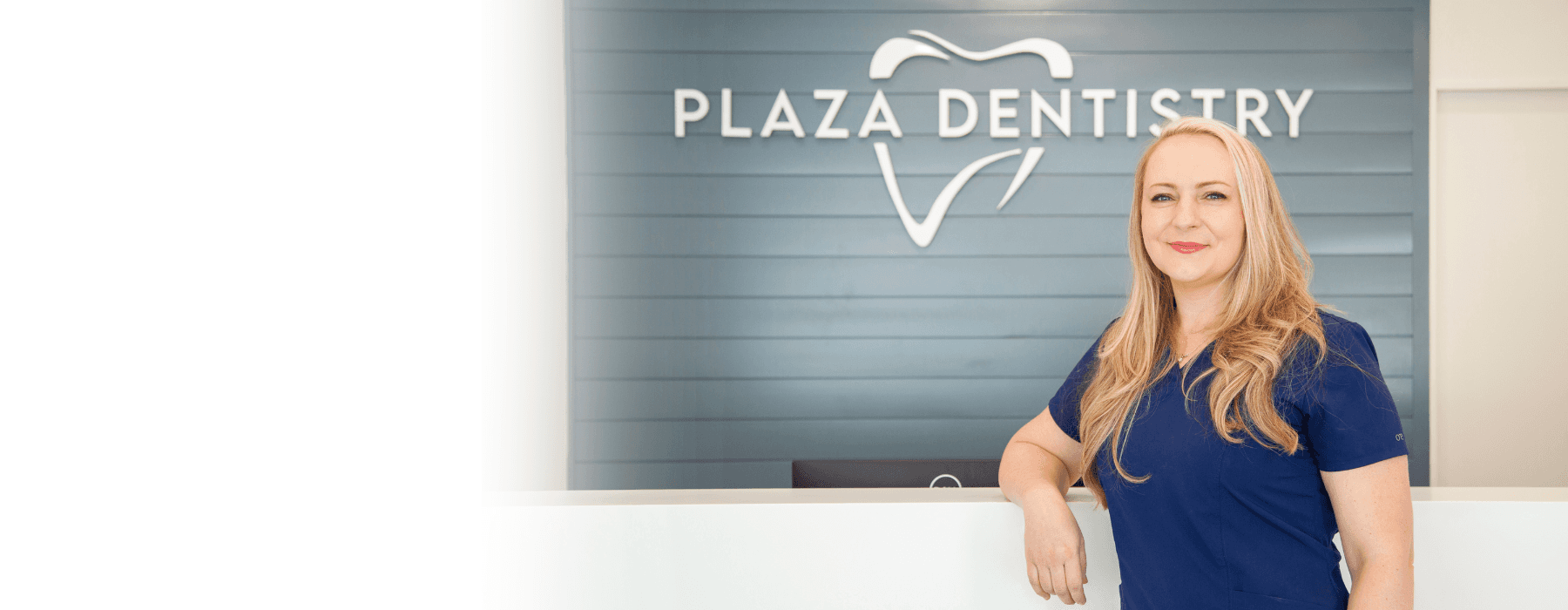 dental hygentist next to office sign | cosmetic dentist teaneck nj